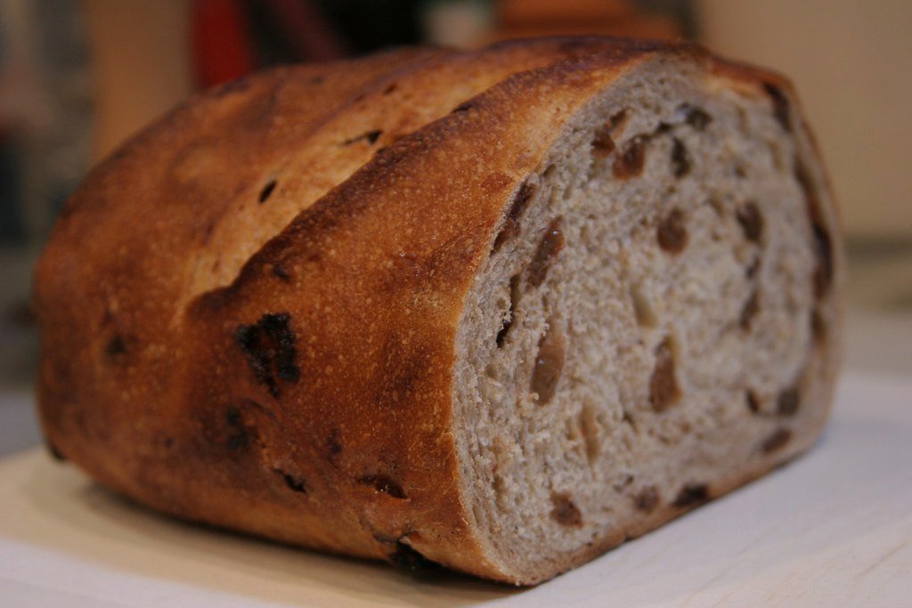 A loaf of raisin bread cut open to show the raisins inside
